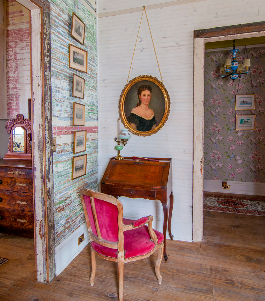 Ejemplo de despacho bohemio pequeño con paredes multicolor, suelo de madera en tonos medios y escritorio independiente