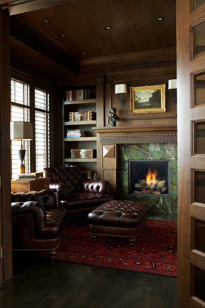 На фото: кабинет в классическом стиле с коричневыми стенами, стандартным камином и фасадом камина из камня с
