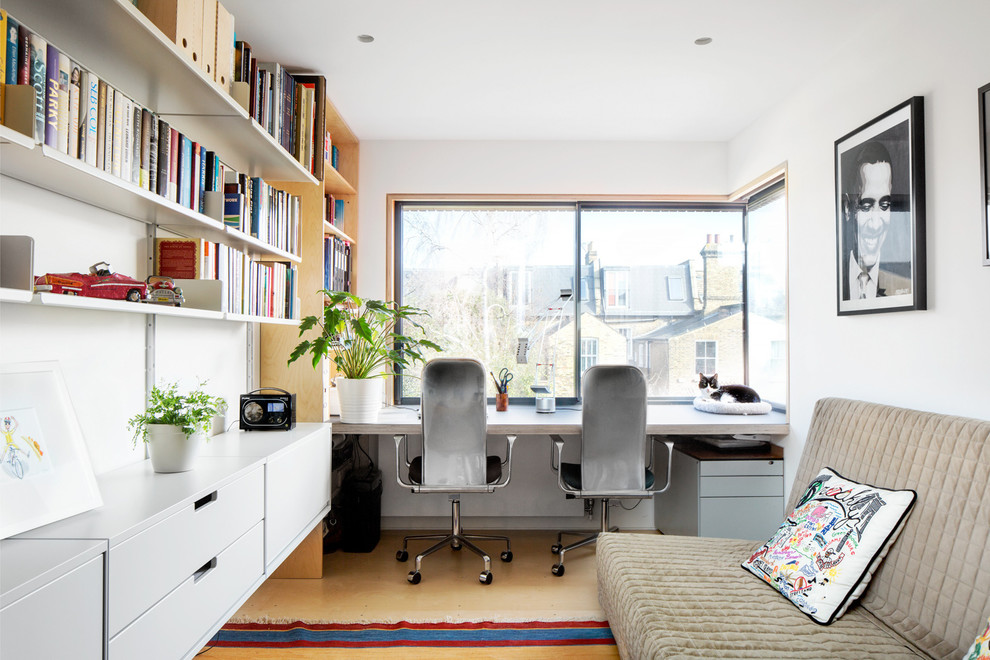ロンドンにある中くらいなコンテンポラリースタイルのおしゃれな書斎 (白い壁、淡色無垢フローリング、造り付け机、グレーの床) の写真