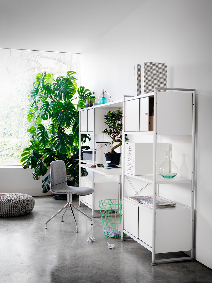 Skandinavisches Arbeitszimmer mit weißer Wandfarbe, Betonboden und freistehendem Schreibtisch in London