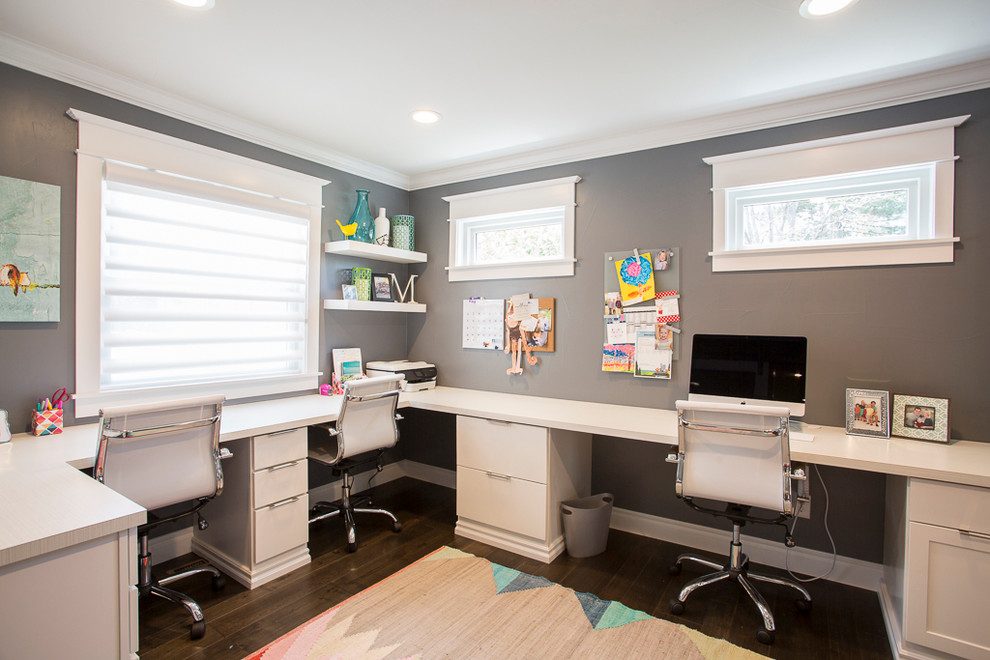 Immagine di un grande ufficio minimalista con pareti grigie, pavimento in legno massello medio, scrivania incassata e pavimento marrone