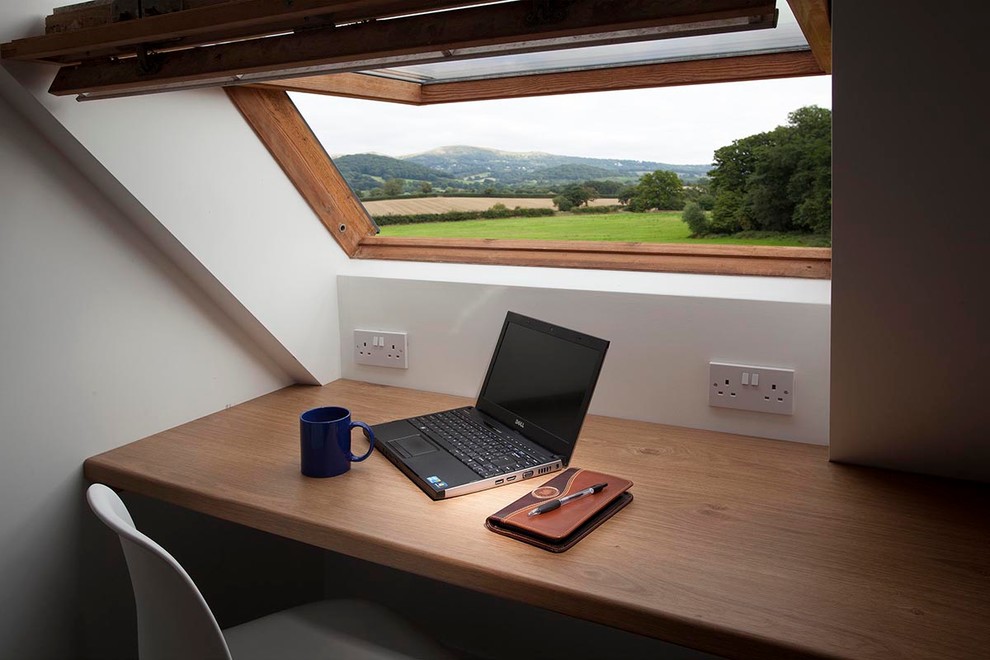 Small farmhouse study in Cornwall with white walls, carpet and a built-in desk.