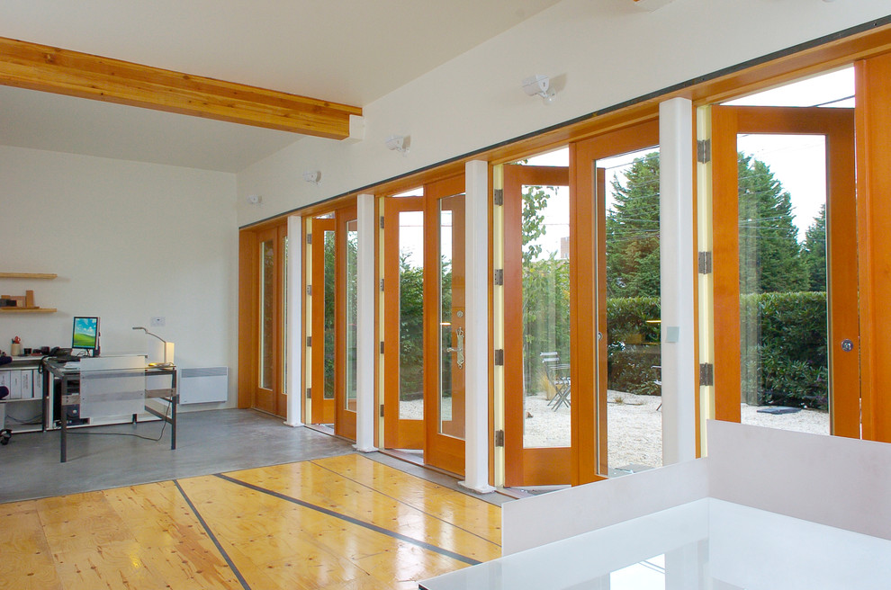 Стильный дизайн: кабинет в стиле модернизм с бетонным полом и белыми стенами - последний тренд