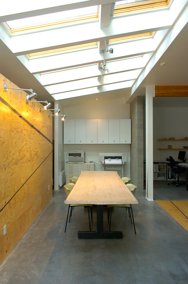 This is an example of a modern home office in Seattle with concrete flooring and grey floors.