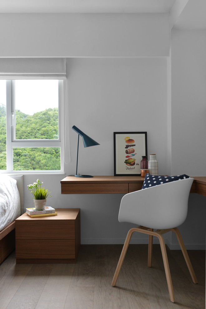 Imagen de despacho nórdico pequeño con paredes blancas, suelo de madera en tonos medios, escritorio empotrado y suelo marrón