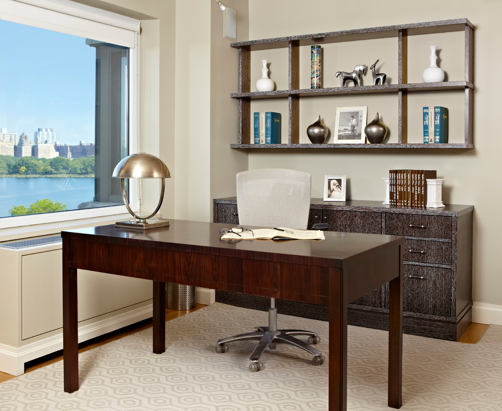 Diseño de despacho clásico renovado grande sin chimenea con paredes beige, escritorio independiente y suelo de madera clara