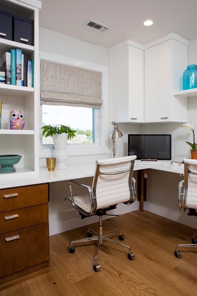 Idee per un piccolo ufficio design con pareti bianche, scrivania incassata e parquet chiaro