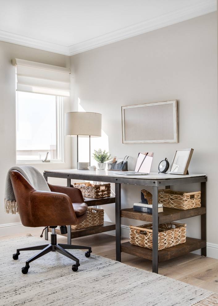 Mittelgroßes Maritimes Arbeitszimmer mit beiger Wandfarbe, hellem Holzboden und freistehendem Schreibtisch in Los Angeles