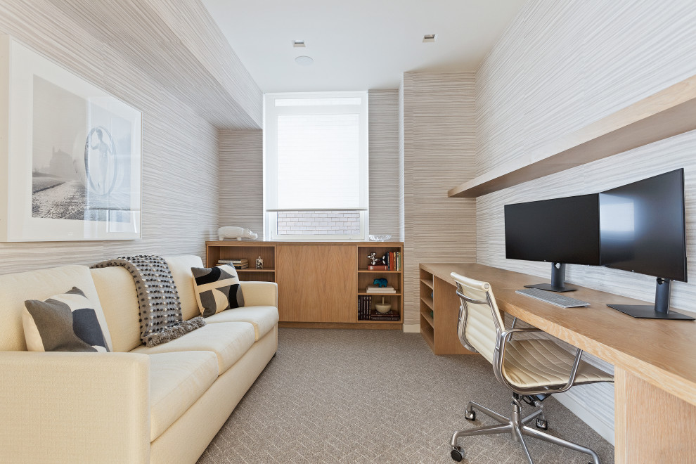 Пример оригинального дизайна: рабочее место в современном стиле с ковровым покрытием, встроенным рабочим столом, бежевым полом, обоями на стенах и серыми стенами без камина