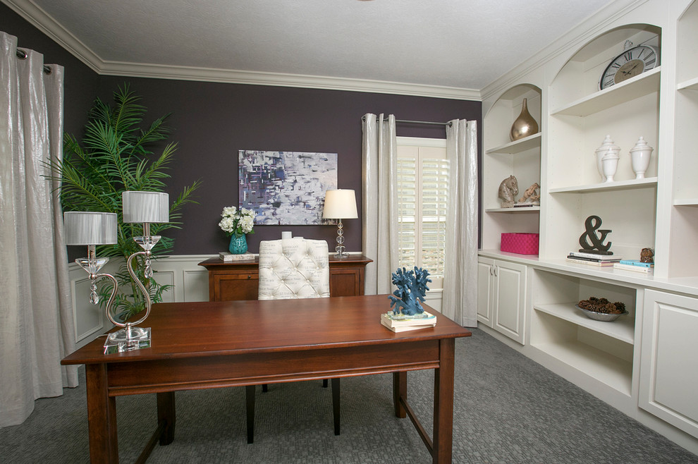 Klassisk inredning av ett arbetsrum, med lila väggar, heltäckningsmatta, ett fristående skrivbord och grått golv