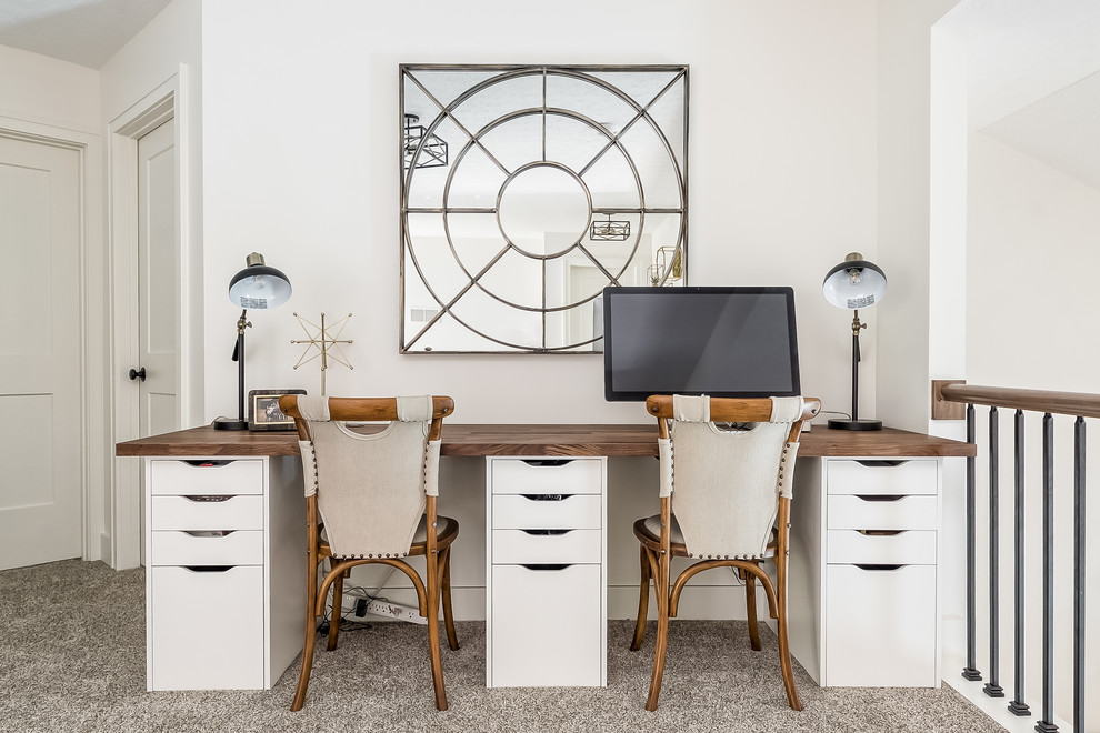 Modelo de despacho tradicional renovado con paredes blancas, moqueta, escritorio empotrado y suelo gris