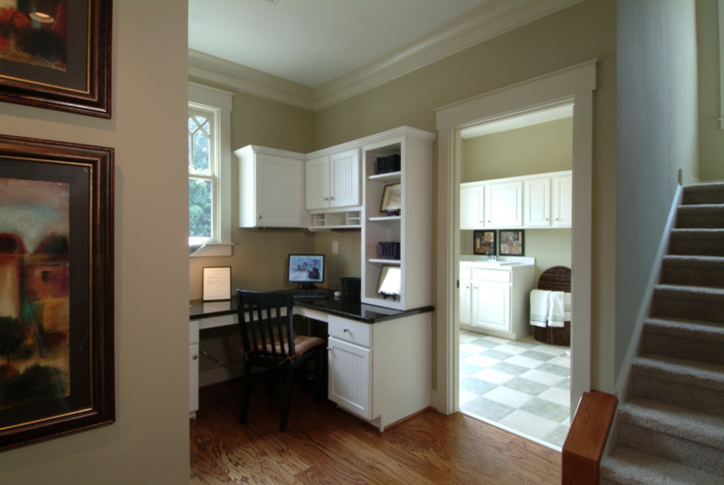 Foto de despacho de estilo americano de tamaño medio sin chimenea con paredes grises, suelo de madera en tonos medios y escritorio empotrado