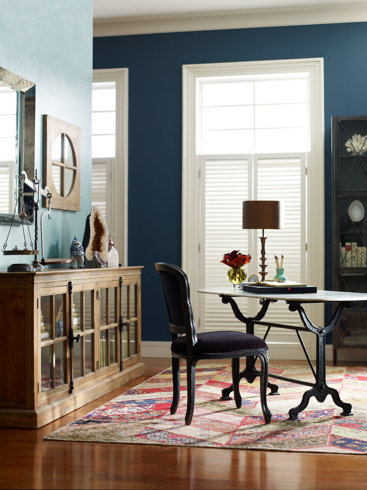 Idee per un grande ufficio eclettico con pareti blu, parquet chiaro e scrivania autoportante