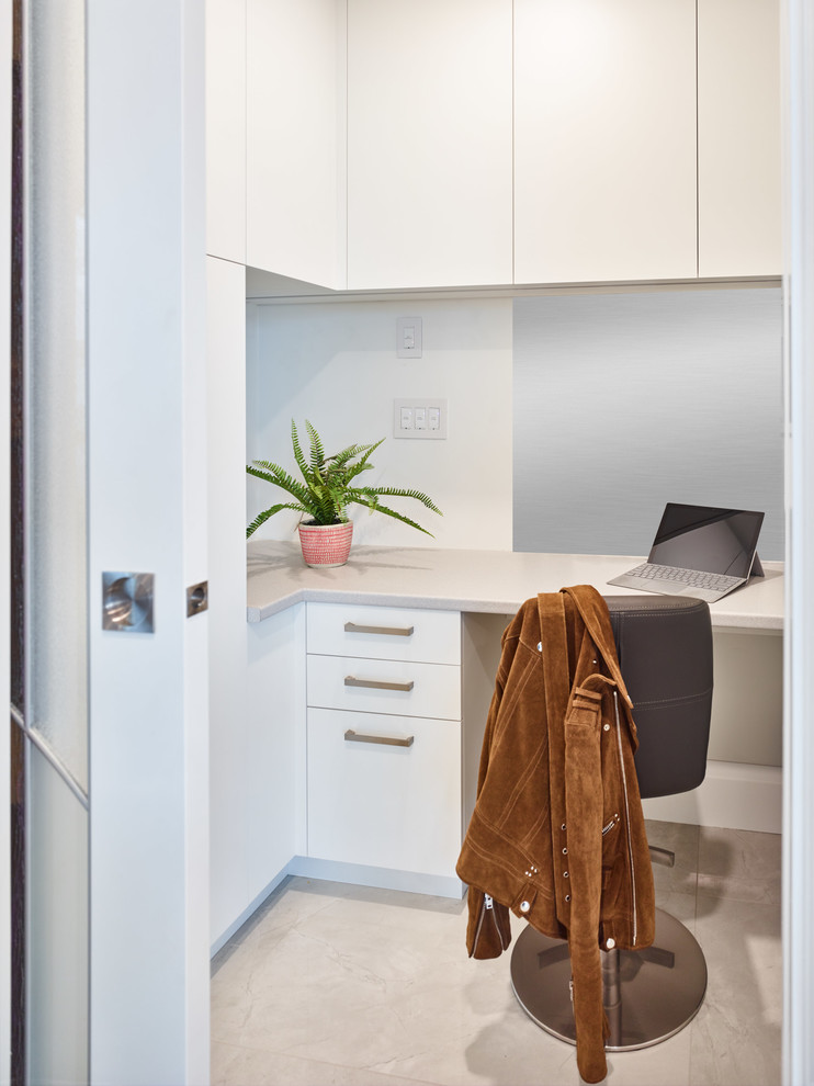 Modern inredning av ett litet arbetsrum, med vita väggar, klinkergolv i porslin, ett inbyggt skrivbord och grått golv