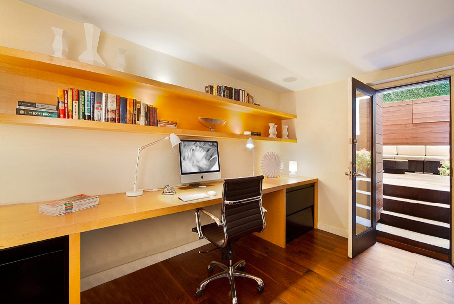 Immagine di un piccolo ufficio minimalista con pareti beige, pavimento in legno massello medio e scrivania incassata