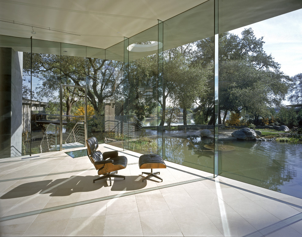 Стильный дизайн: большое рабочее место в стиле модернизм с белыми стенами, полом из известняка и встроенным рабочим столом без камина - последний тренд