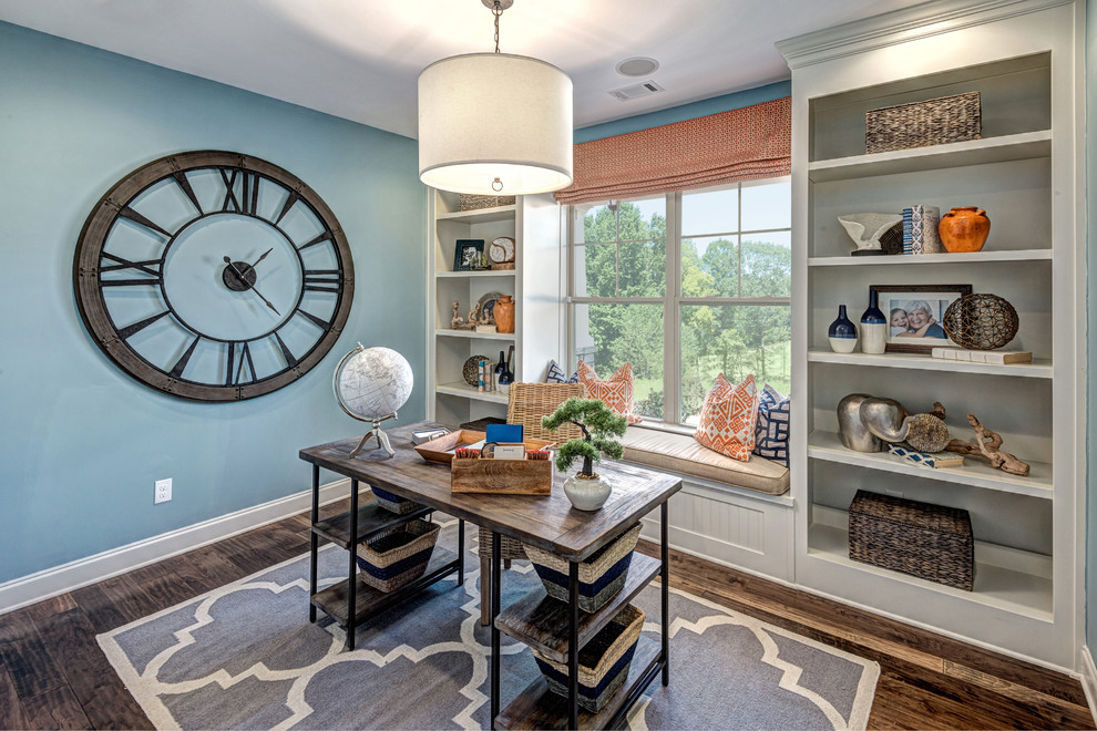 Idéer för ett klassiskt hemmabibliotek, med blå väggar, mellanmörkt trägolv och ett fristående skrivbord