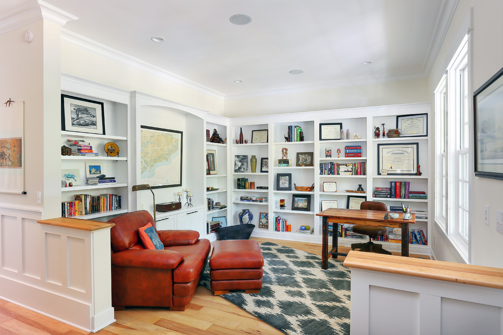 Diseño de despacho clásico de tamaño medio con paredes beige, suelo de madera en tonos medios y escritorio independiente