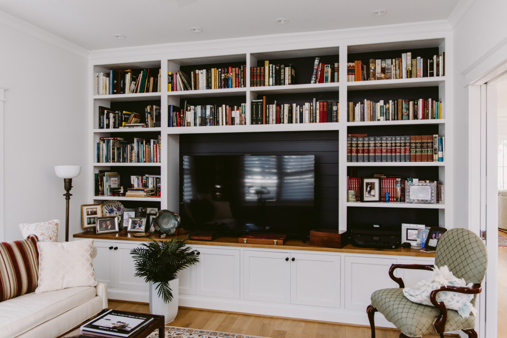 Esempio di uno studio chic di medie dimensioni con libreria, pareti bianche, pavimento in legno massello medio e pavimento marrone