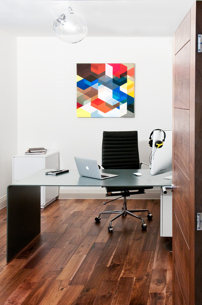 Diseño de despacho actual con paredes blancas, suelo de madera oscura y escritorio independiente