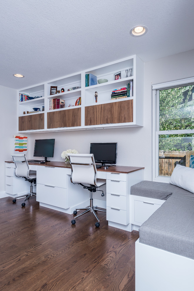 Immagine di un ufficio minimalista con parquet scuro e scrivania incassata