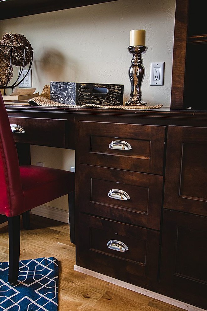 Imagen de despacho de estilo americano grande sin chimenea con paredes beige, suelo de madera clara y escritorio empotrado