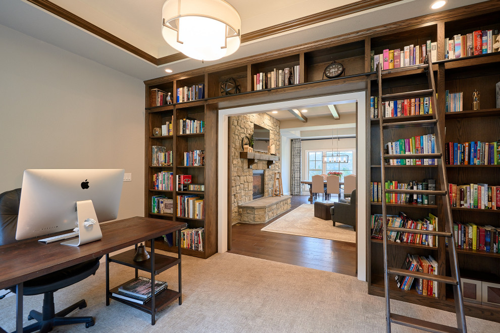 Rustik inredning av ett mellanstort arbetsrum, med ett bibliotek, grå väggar, heltäckningsmatta, ett fristående skrivbord och grått golv