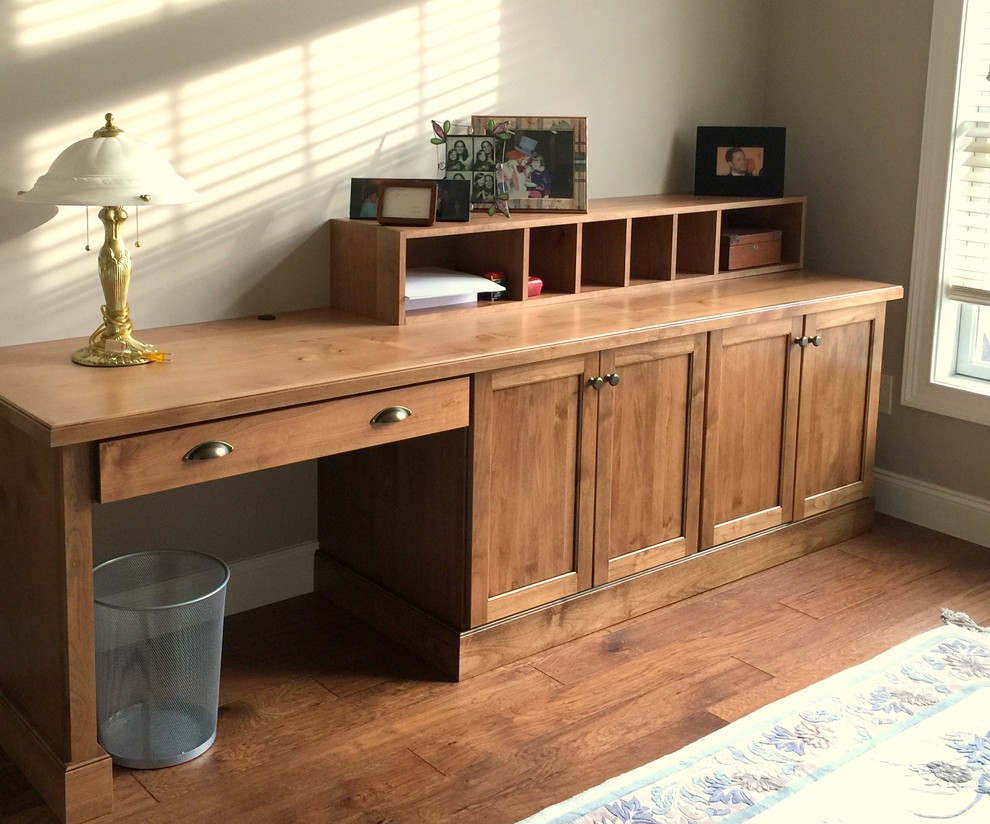 Kleines Klassisches Arbeitszimmer ohne Kamin mit Arbeitsplatz, beiger Wandfarbe, braunem Holzboden und Einbau-Schreibtisch in New York