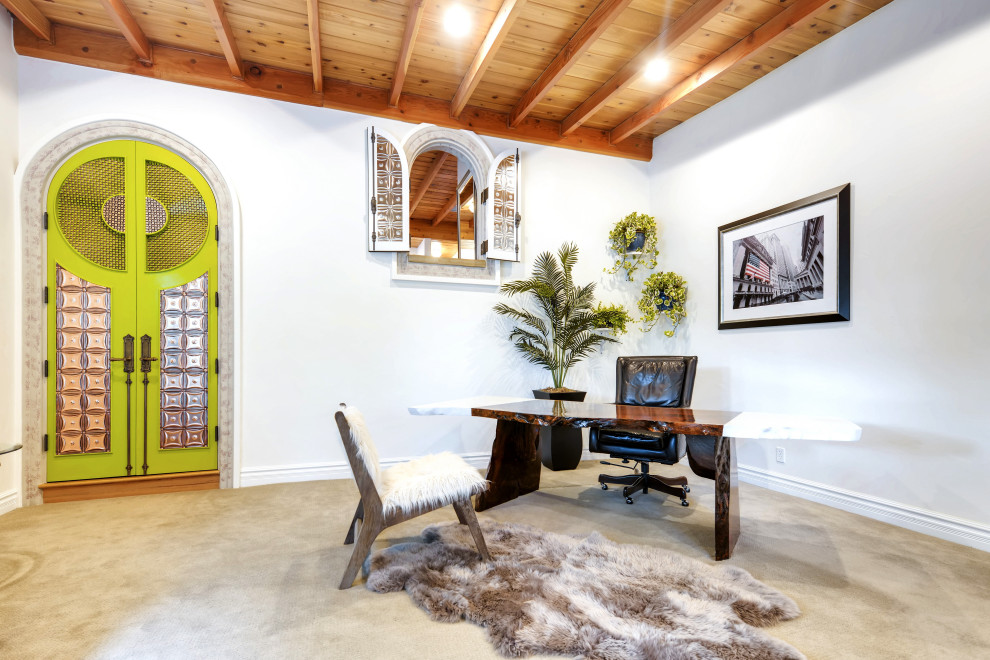 Diseño de despacho mediterráneo grande con escritorio independiente, paredes blancas y suelo beige