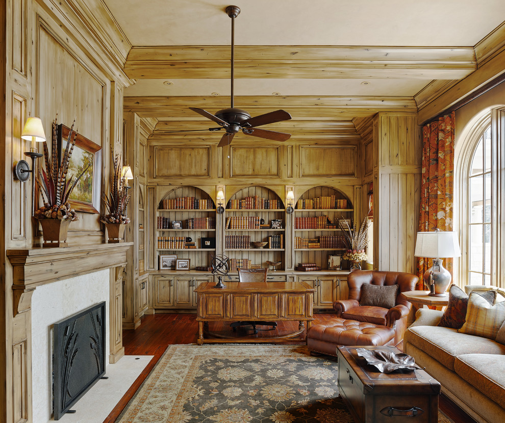 Inspiration för medelhavsstil hemmabibliotek, med beige väggar, mörkt trägolv, en standard öppen spis och ett fristående skrivbord
