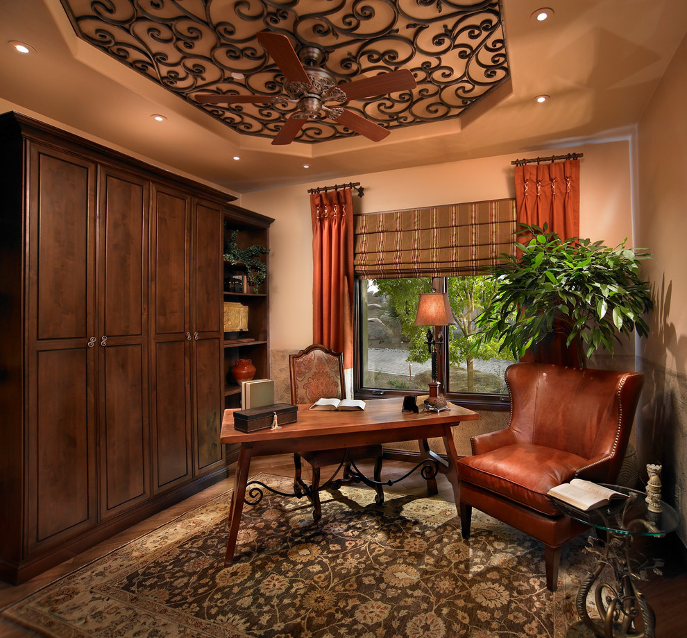 This is an example of a mediterranean home office in Other with beige walls and a freestanding desk.