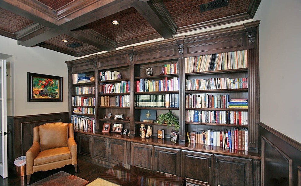 Foto på ett mellanstort medelhavsstil hemmabibliotek, med grå väggar, mörkt trägolv och ett fristående skrivbord
