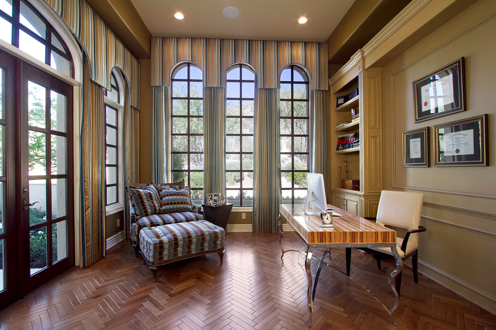 Exempel på ett stort klassiskt arbetsrum, med beige väggar, mörkt trägolv, ett fristående skrivbord och brunt golv