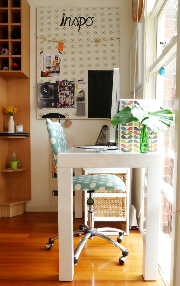 Stilmix Arbeitszimmer mit Arbeitsplatz, weißer Wandfarbe, braunem Holzboden und freistehendem Schreibtisch in Melbourne