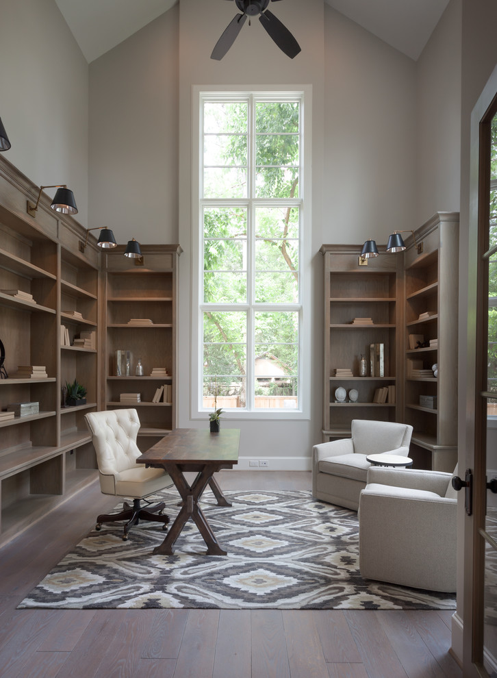 Ejemplo de despacho clásico renovado grande sin chimenea con paredes grises, suelo de madera oscura y escritorio independiente