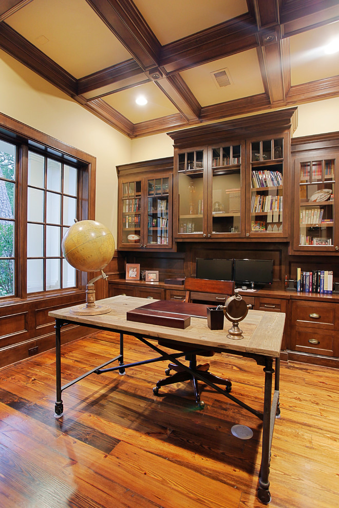 Klassisk inredning av ett arbetsrum, med beige väggar, mellanmörkt trägolv och ett fristående skrivbord