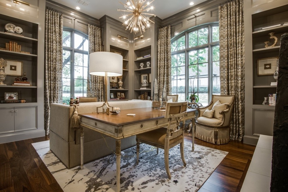 This is an example of a large traditional study in Dallas with beige walls, dark hardwood flooring, no fireplace, a freestanding desk and brown floors.
