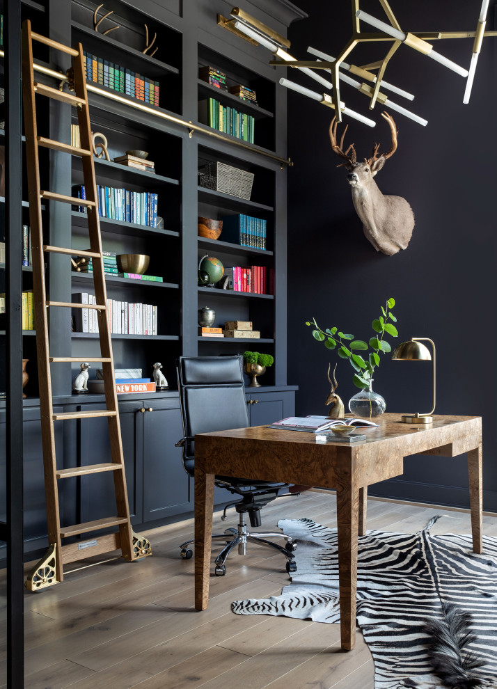 Diseño de despacho actual extra grande con paredes azules, suelo de madera clara, escritorio independiente y suelo marrón