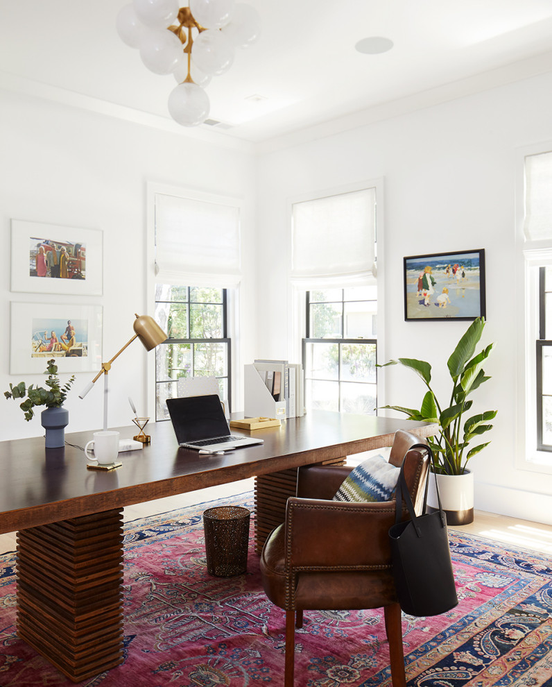 Imagen de despacho clásico renovado con paredes blancas, suelo de madera clara, escritorio independiente y suelo beige