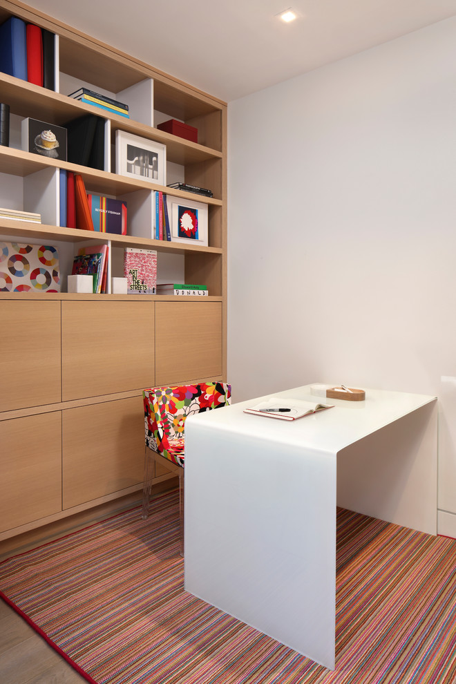 Immagine di un piccolo ufficio design con pareti bianche, parquet chiaro e scrivania autoportante