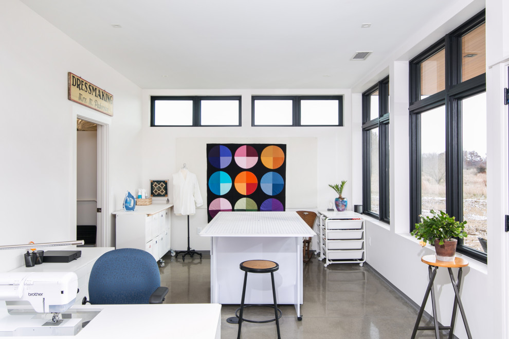 Idéer för ett modernt hobbyrum, med vita väggar, betonggolv, ett fristående skrivbord och grått golv