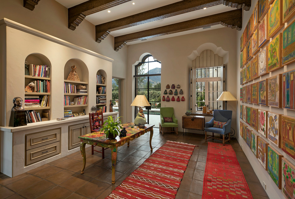 サンタバーバラにあるラグジュアリーな地中海スタイルのおしゃれな書斎 (ベージュの壁、テラコッタタイルの床、暖炉なし、自立型机) の写真