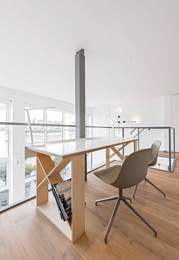 Imagen de despacho contemporáneo de tamaño medio sin chimenea con paredes blancas, suelo de madera clara y escritorio independiente