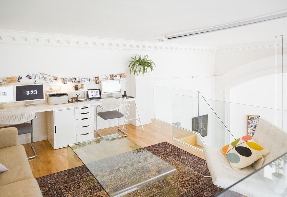 Kleines Skandinavisches Arbeitszimmer ohne Kamin mit Studio, weißer Wandfarbe, braunem Holzboden und Einbau-Schreibtisch in Edinburgh