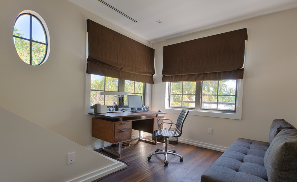 Idee per un ufficio minimal di medie dimensioni con pareti beige, parquet scuro, nessun camino e scrivania autoportante