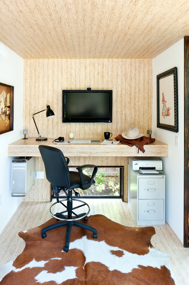 オースティンにあるコンテンポラリースタイルのおしゃれなホームオフィス・書斎 (淡色無垢フローリング、造り付け机、ベージュの壁) の写真