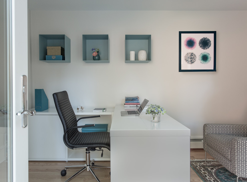 Diseño de despacho contemporáneo de tamaño medio sin chimenea con paredes blancas, suelo de madera clara y escritorio empotrado