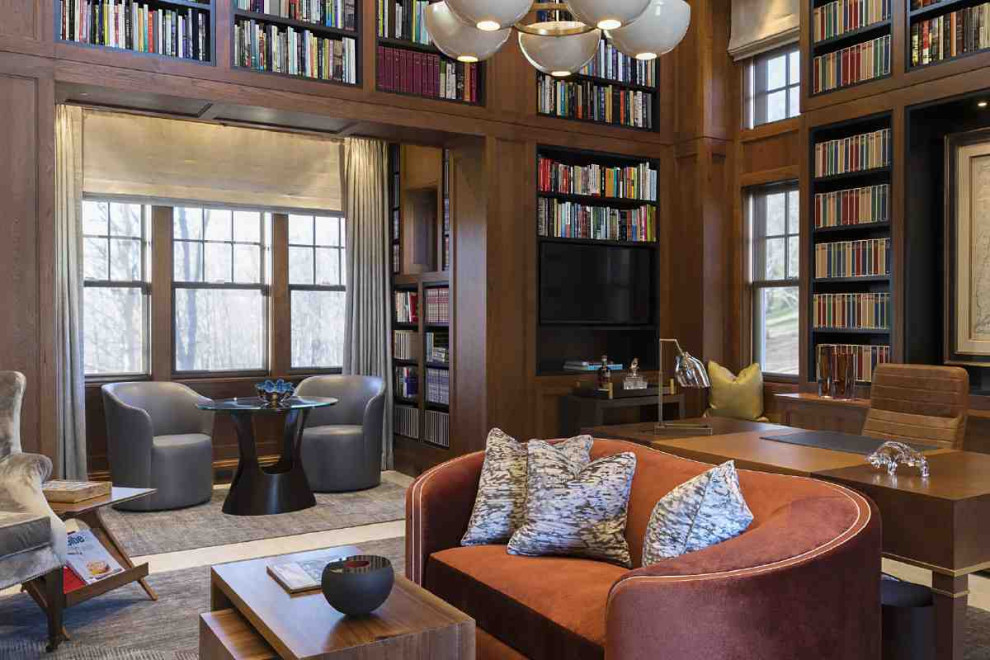 Стильный дизайн: домашняя библиотека в стиле ретро с коричневыми стенами, мраморным полом, стандартным камином, фасадом камина из камня, отдельно стоящим рабочим столом и разноцветным полом - последний тренд