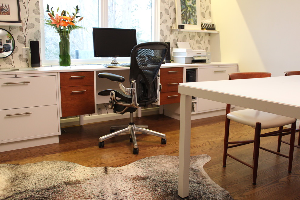 Exemple d'un bureau rétro de taille moyenne et de type studio avec un mur blanc, un sol en bois brun et un bureau intégré.