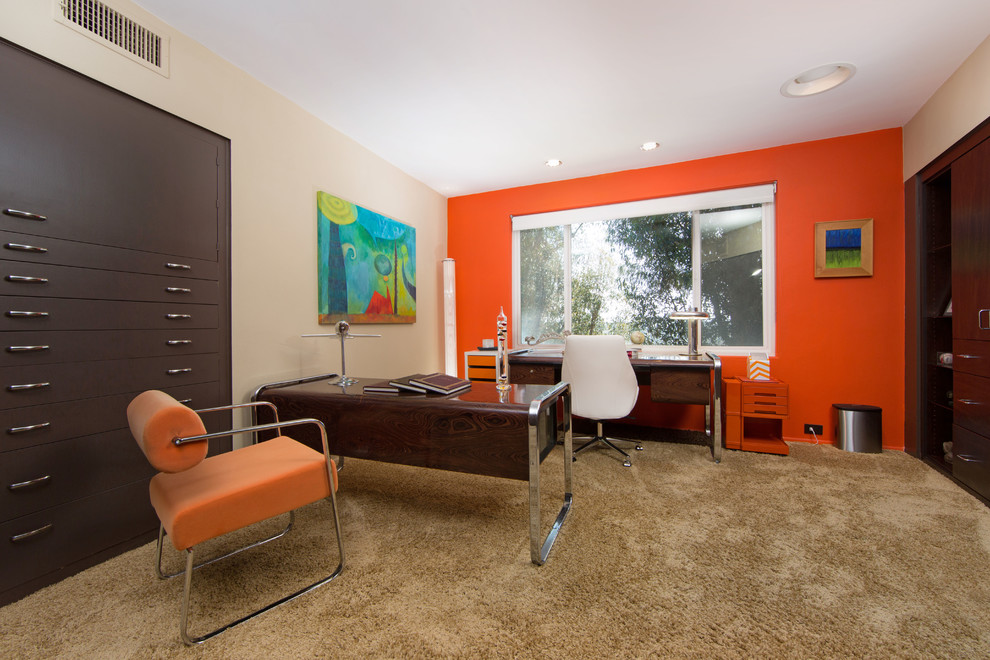 Foto de despacho retro de tamaño medio sin chimenea con parades naranjas, moqueta y escritorio independiente
